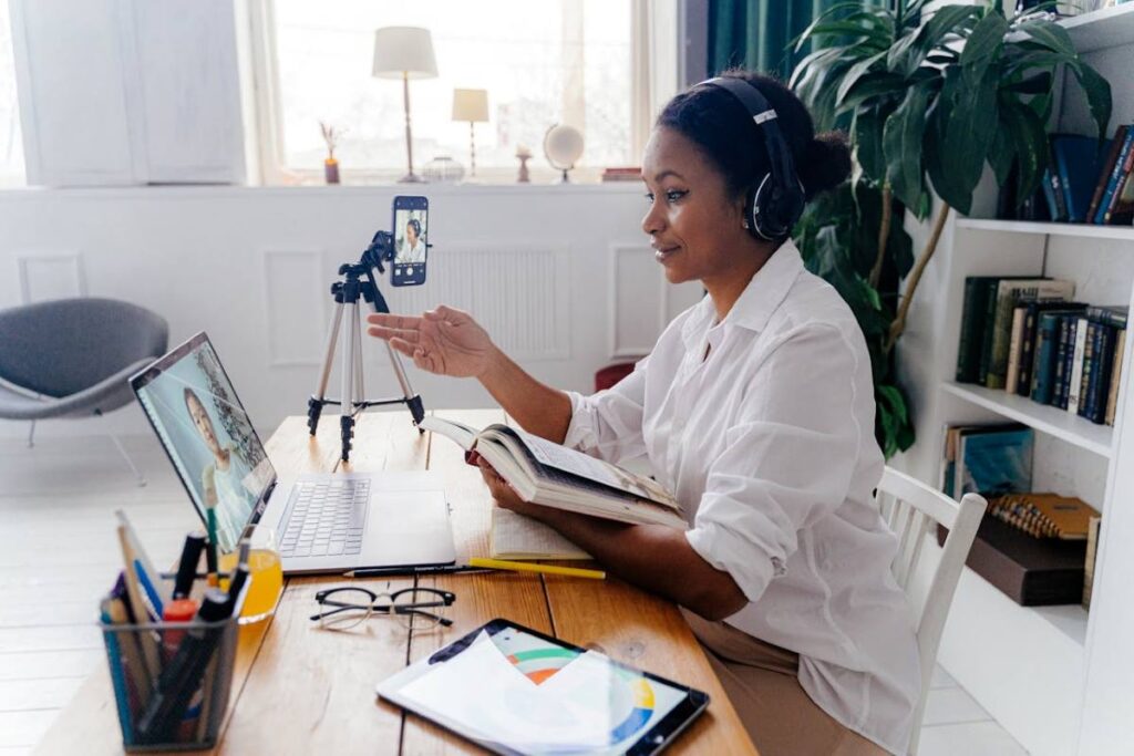 a woman talking to someone virtually on her laptop, partaking the virtual book event ideas